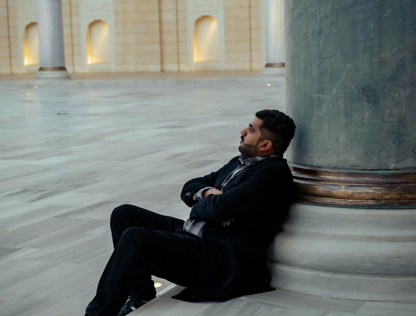 a man sitting on a pillar in a large building 20557352 scaled e1717691619915